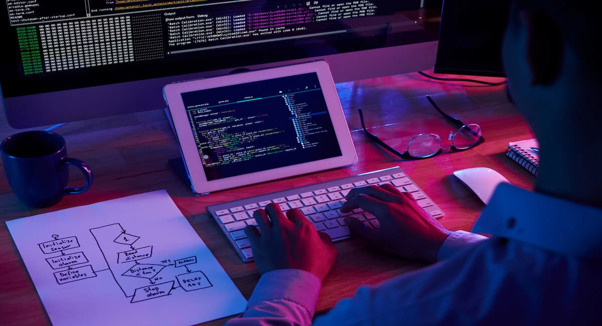 man working on laptop with neon noir aesthetic