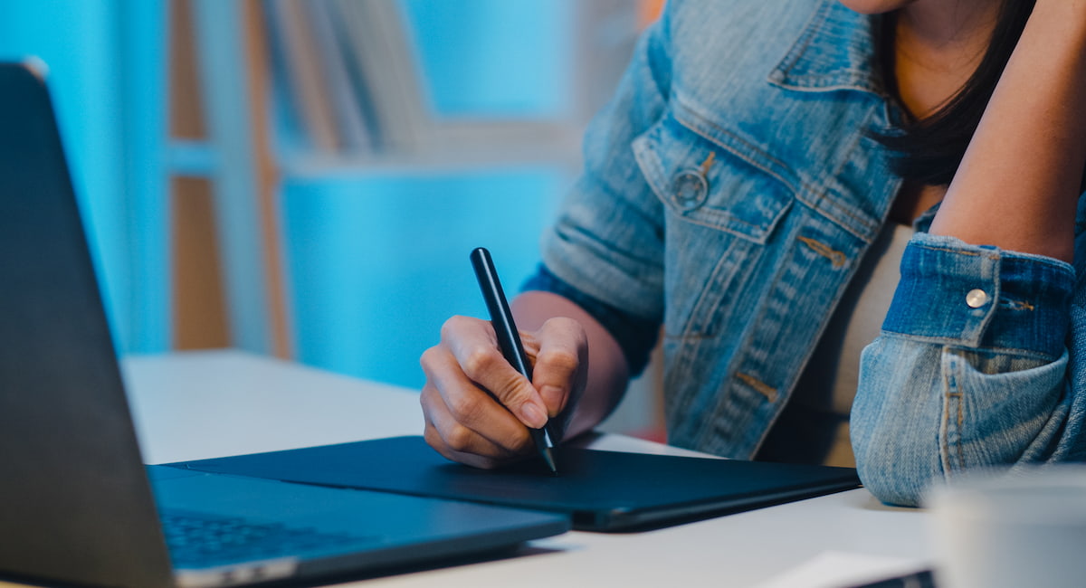 Person in denim jacket working on art tab